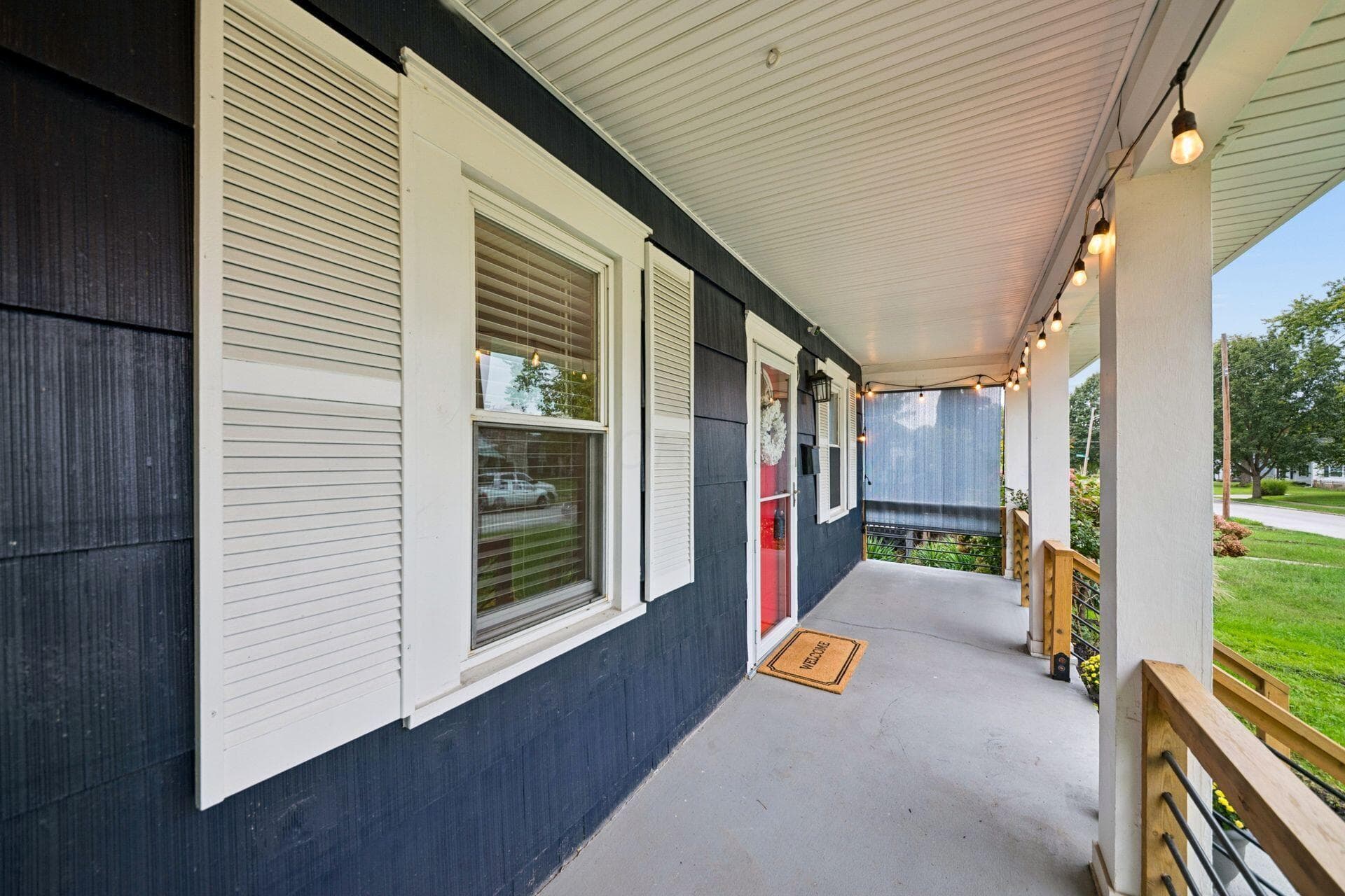 Plenty of space for chairs and a porch swing with charming cafe lights