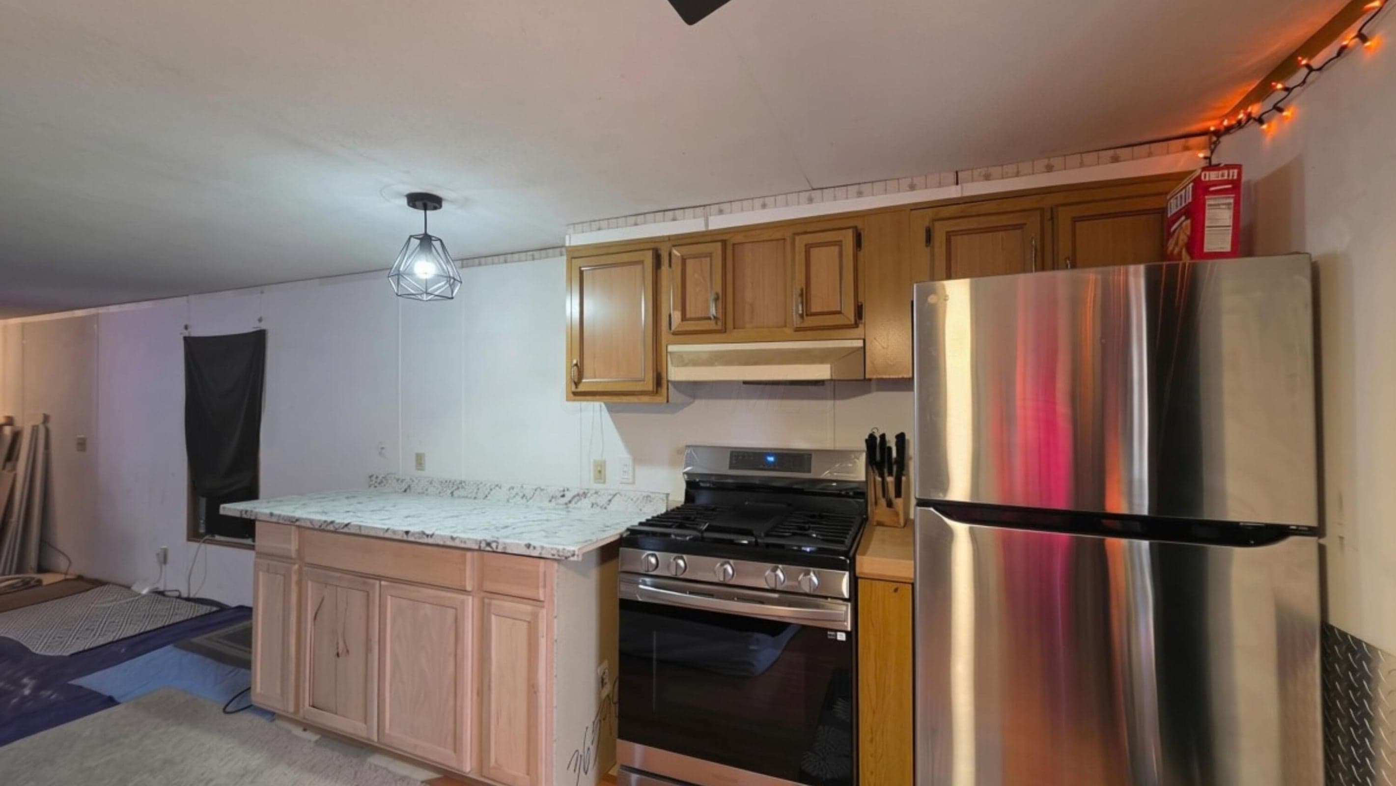 Kitchen with wood cabinetry, stainless steel refrigerator, and built-in gas range