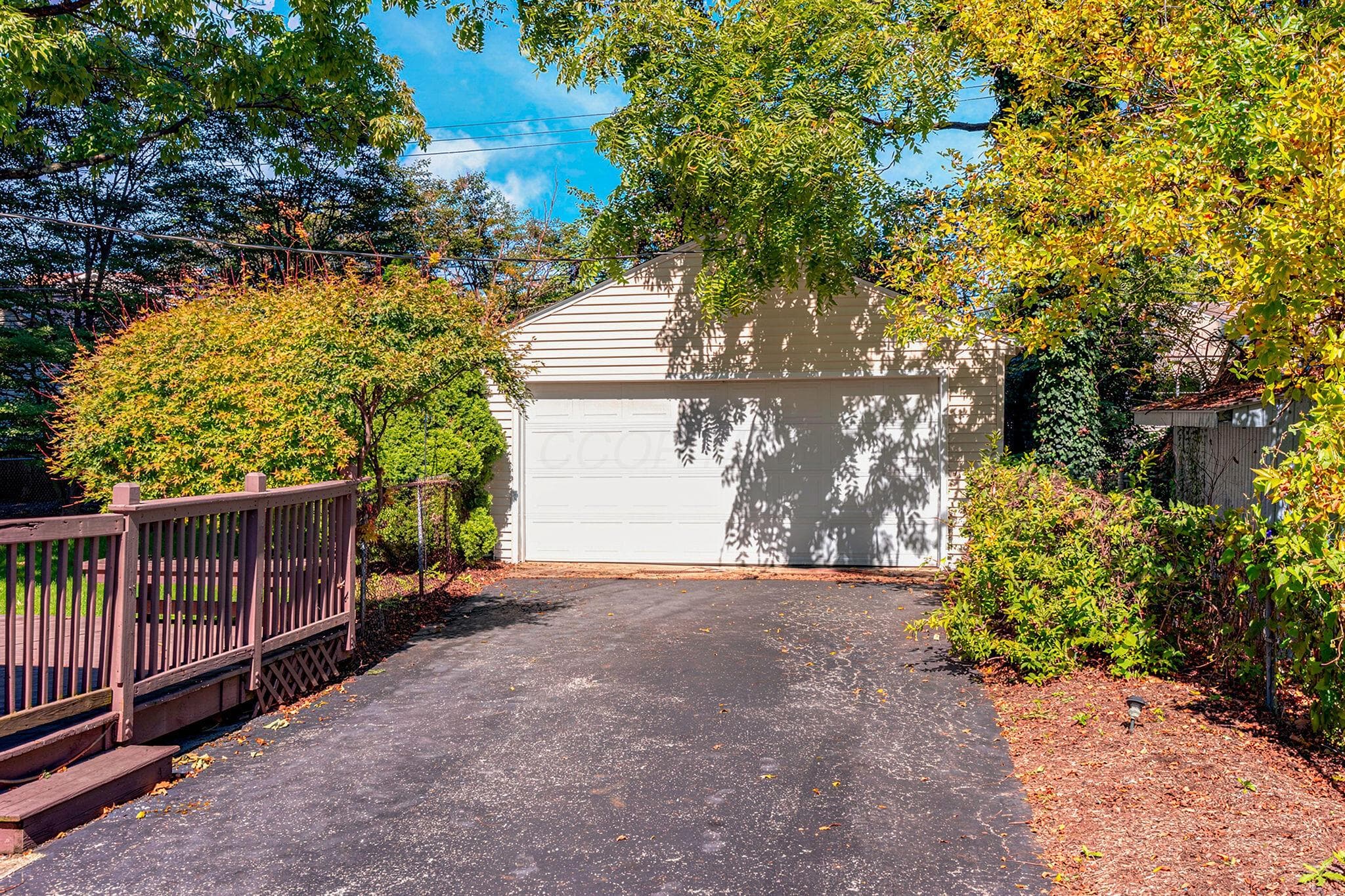 Detached two-car garage with openers and long driveway.