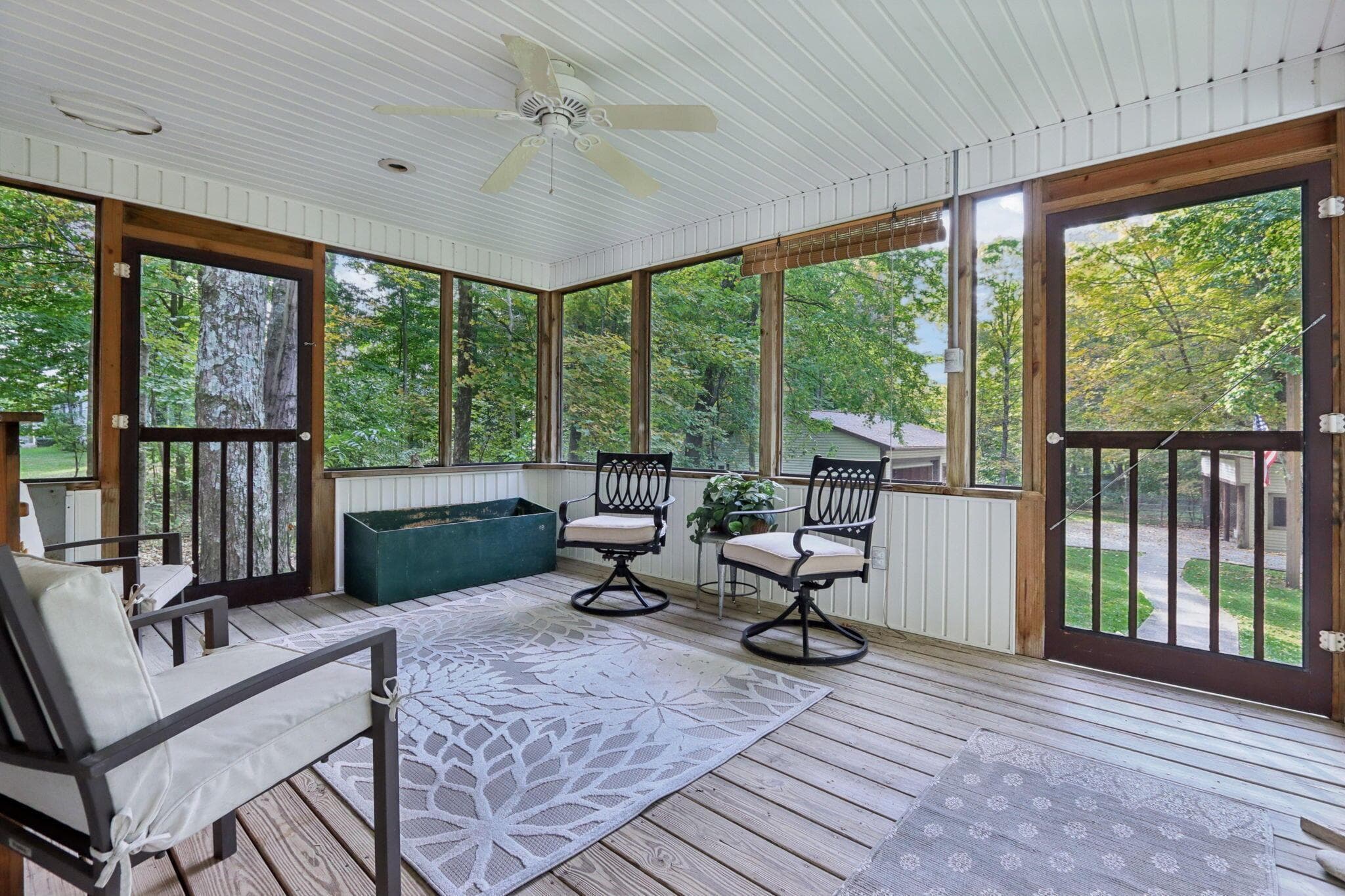 Screened porch with firewood storage box and pet escape door to fenced pen area