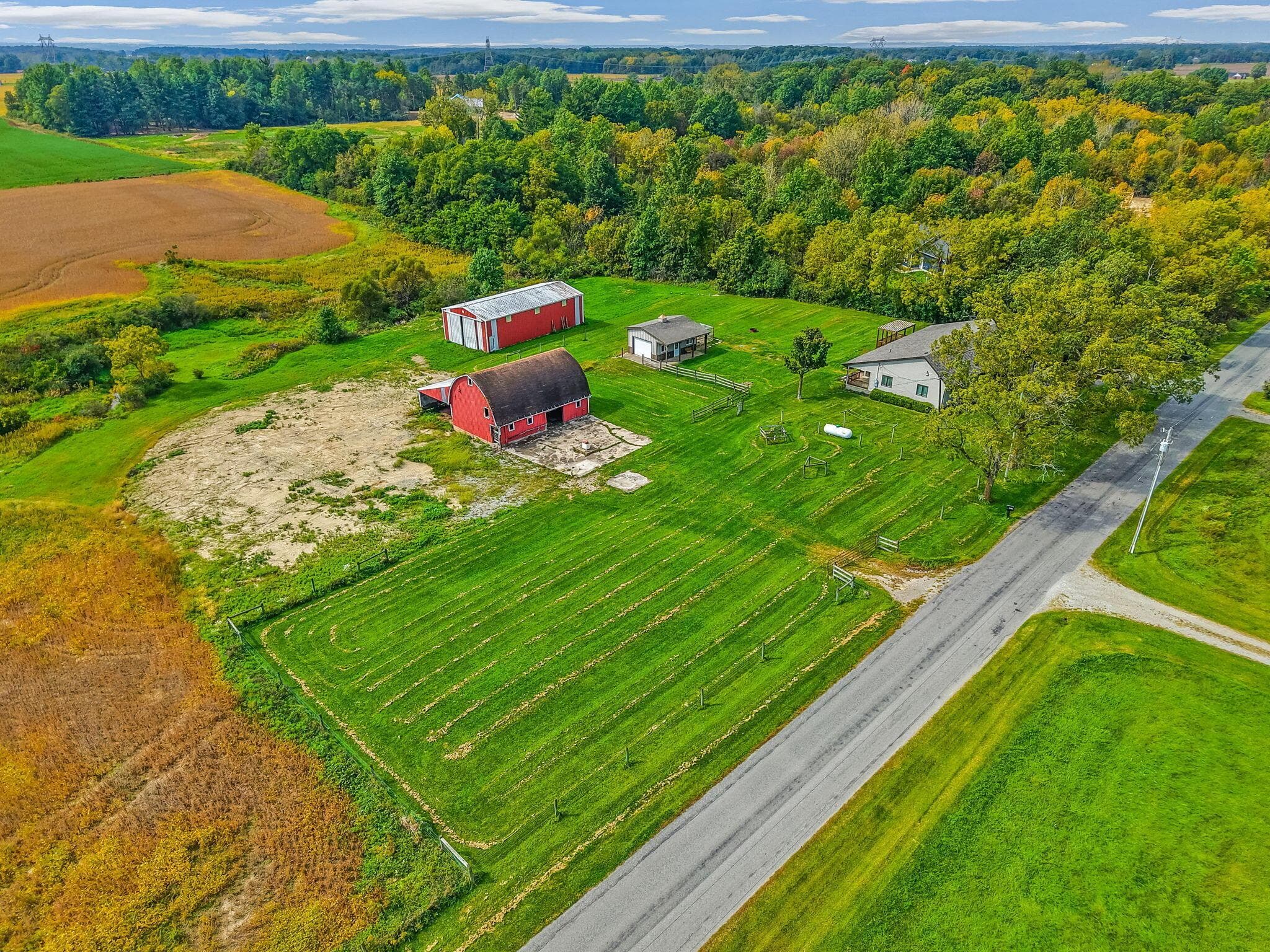Expansive parcel featuring a main residence, two red barns, and a detached building