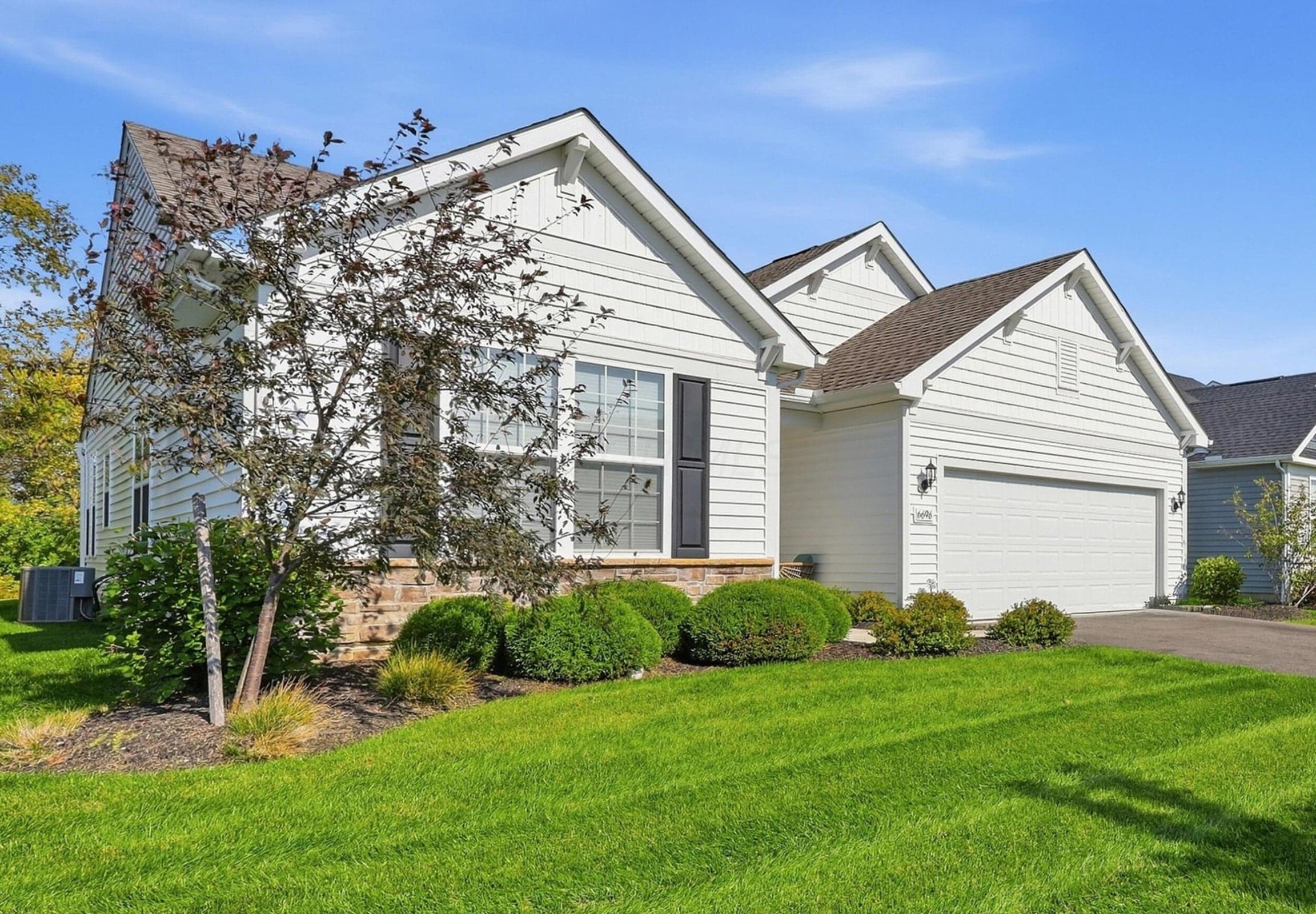 White siding exterior with a stone accent foundation