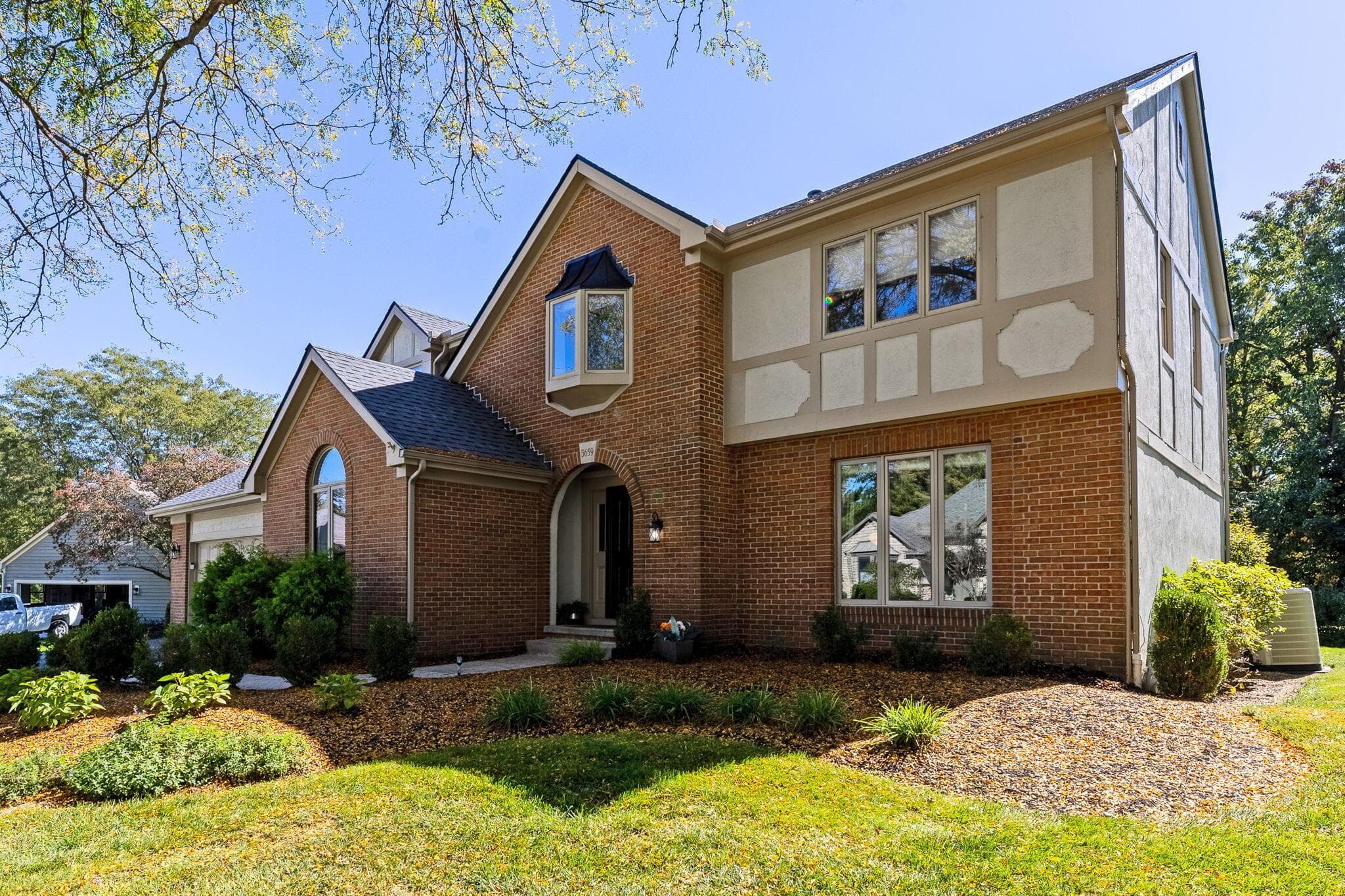 Brick and stucco exterior with multiple gables and a bay window