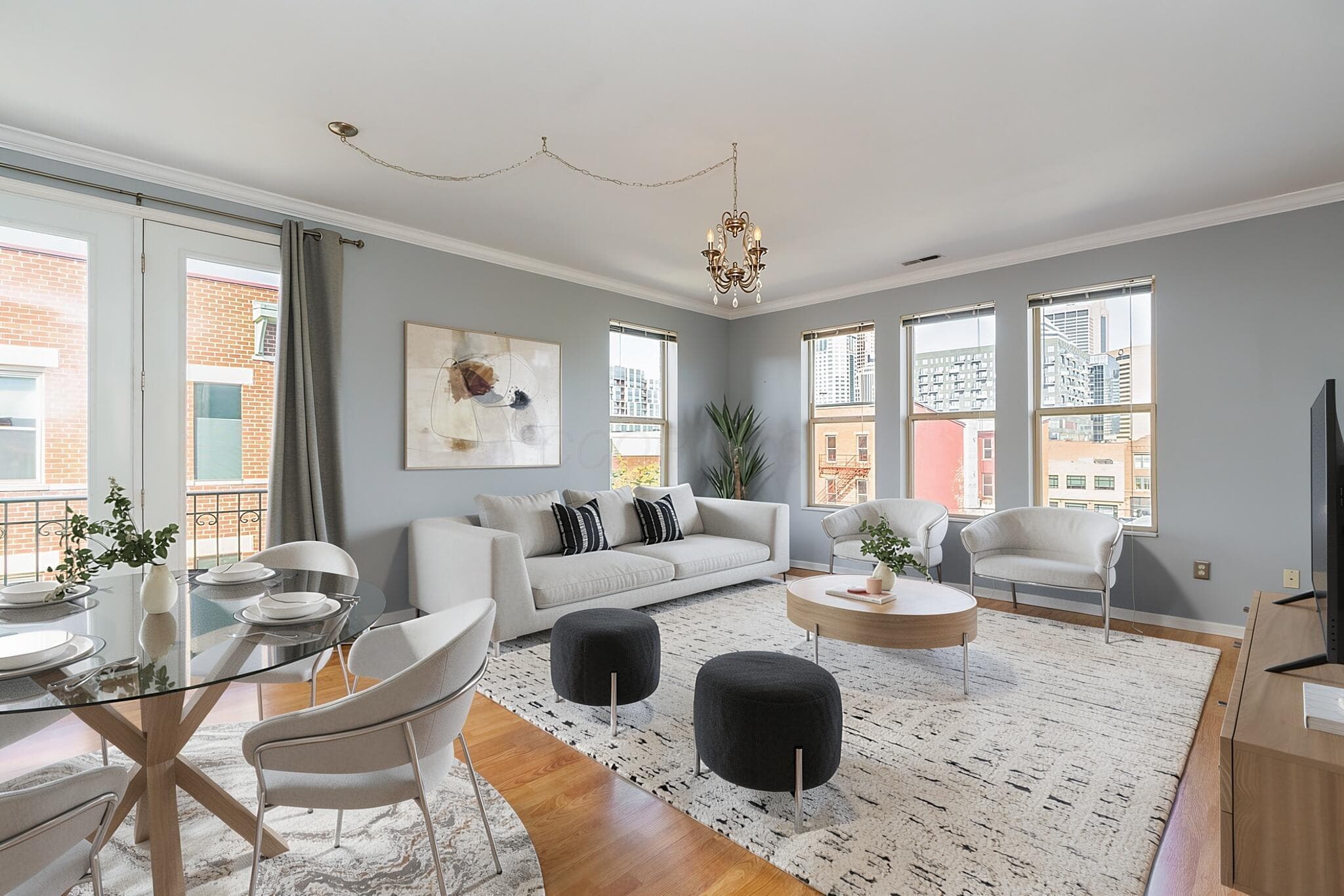 Top floor corner unit with extra windows, french doors with Juliet balcony and views of the downtown skyline - Virtually Staged
