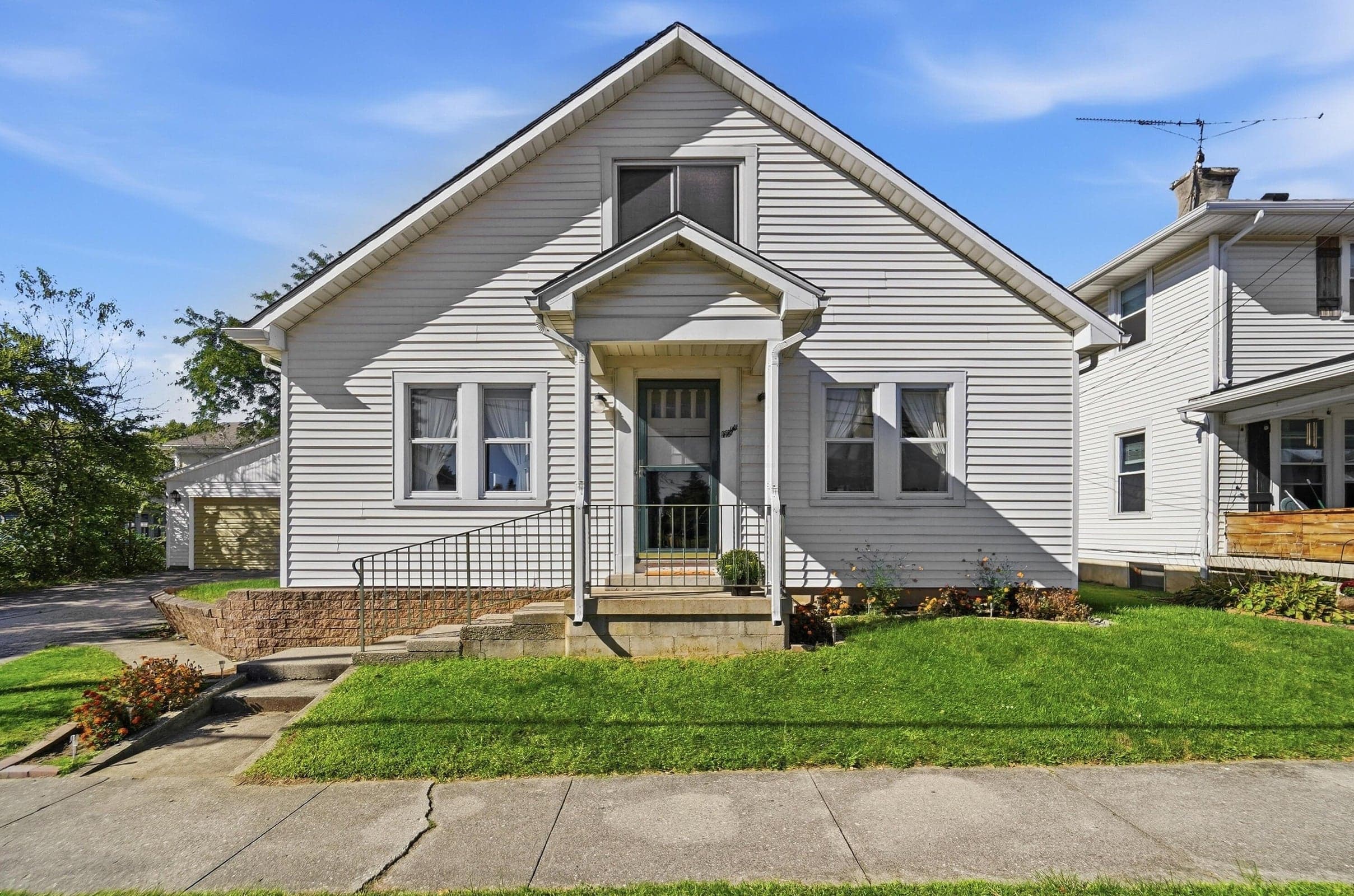 White-sided exterior with a gabled roofline and front porch