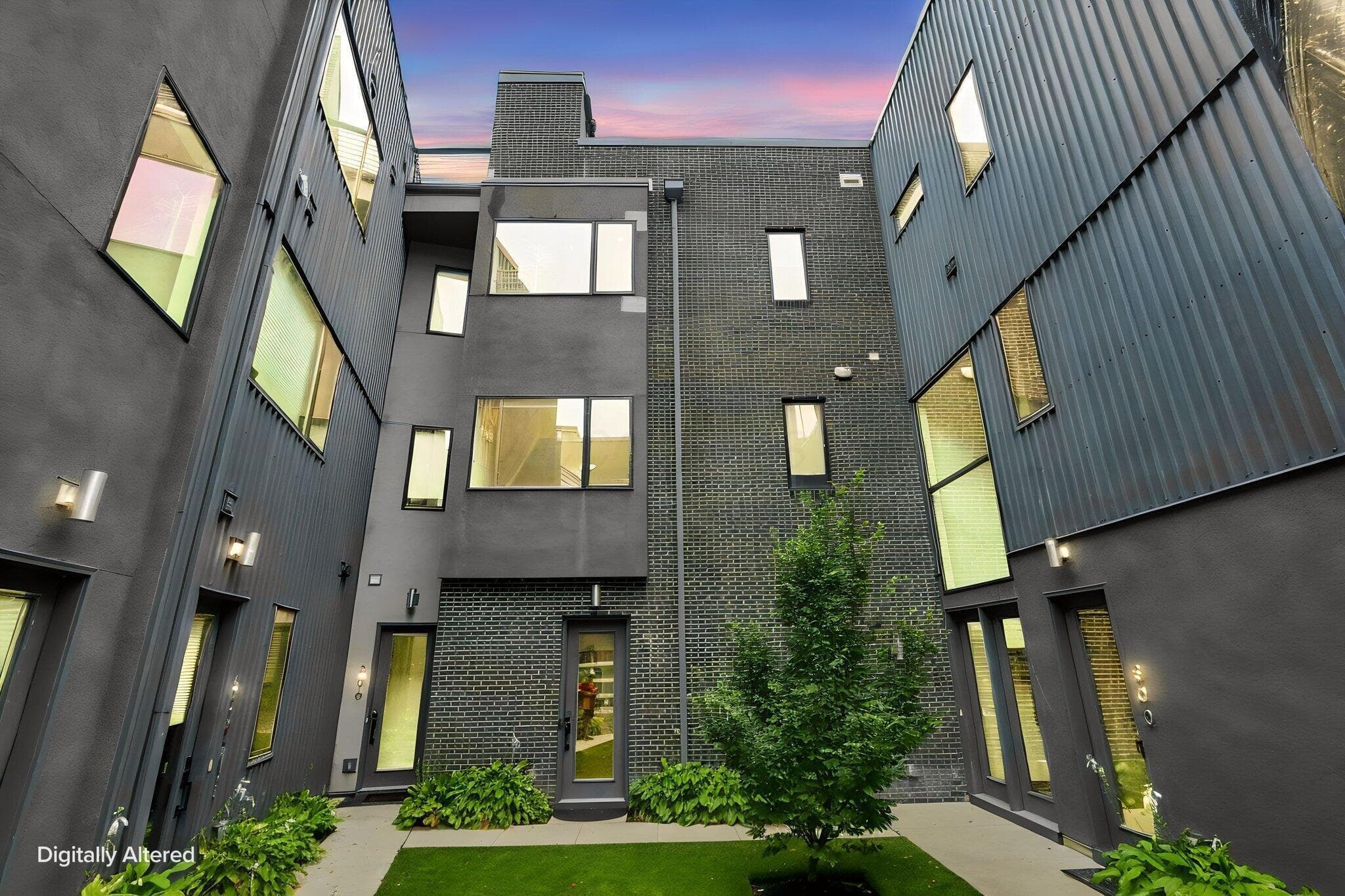 Modern architectural design featuring dark brick, corrugated metal siding, and multiple window styles