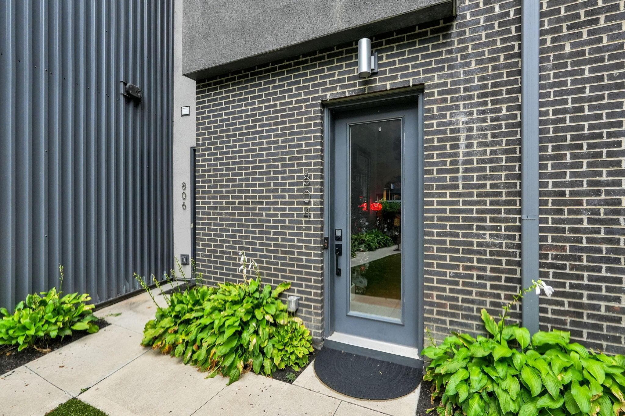 Modern facade featuring dark brickwork and corrugated metal siding