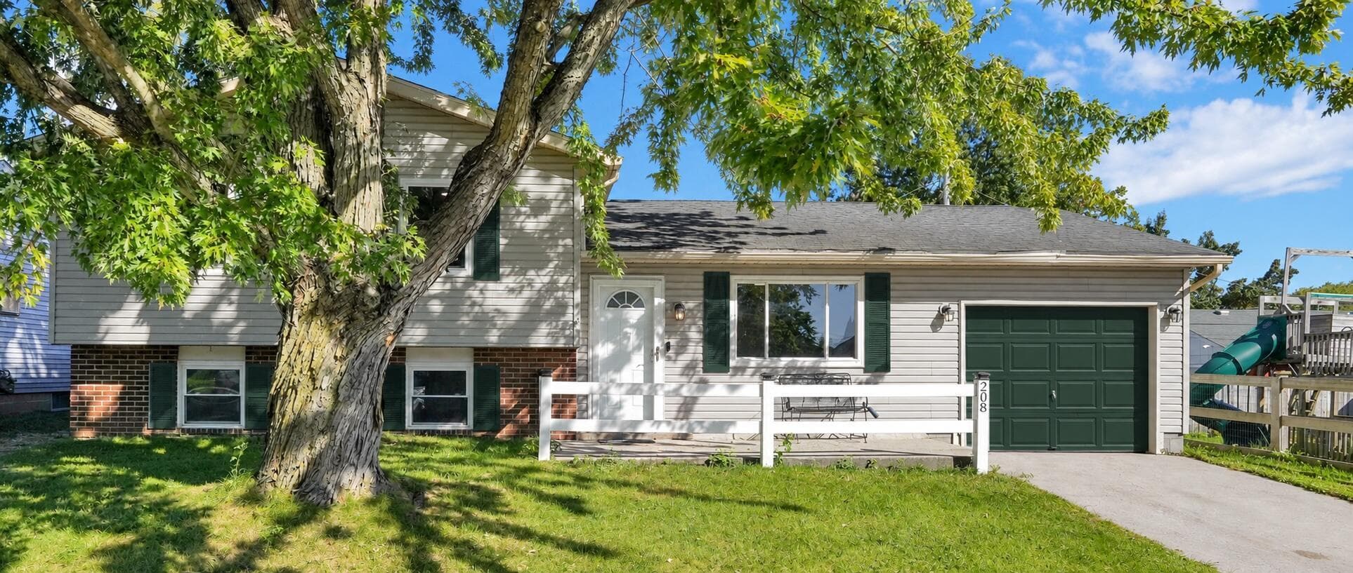 Mature tree, white split-rail fence, lovely front patio, and freshly painted garage door and shutters...what a WONDERFUL place to spend your evenings!