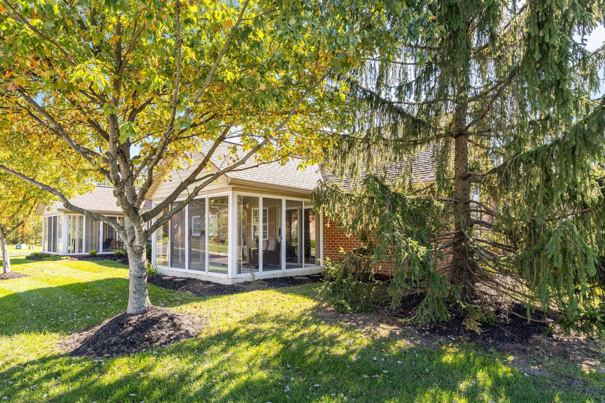 A 3-season vaulted sun room with views of mature trees and the well-kept condo community with pond.