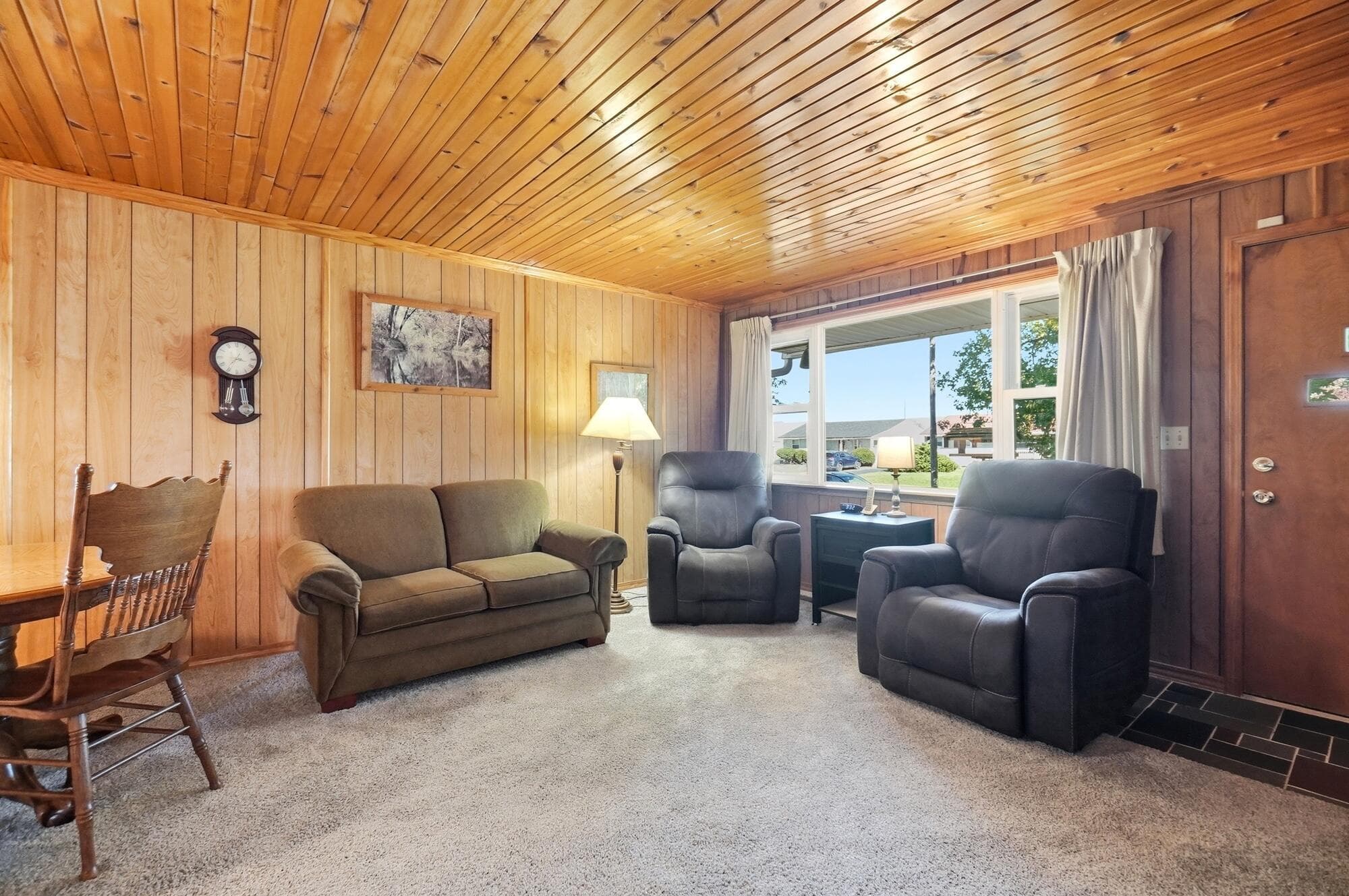 Knotty pine ceiling and a big picture window looking out on the front yard tree.