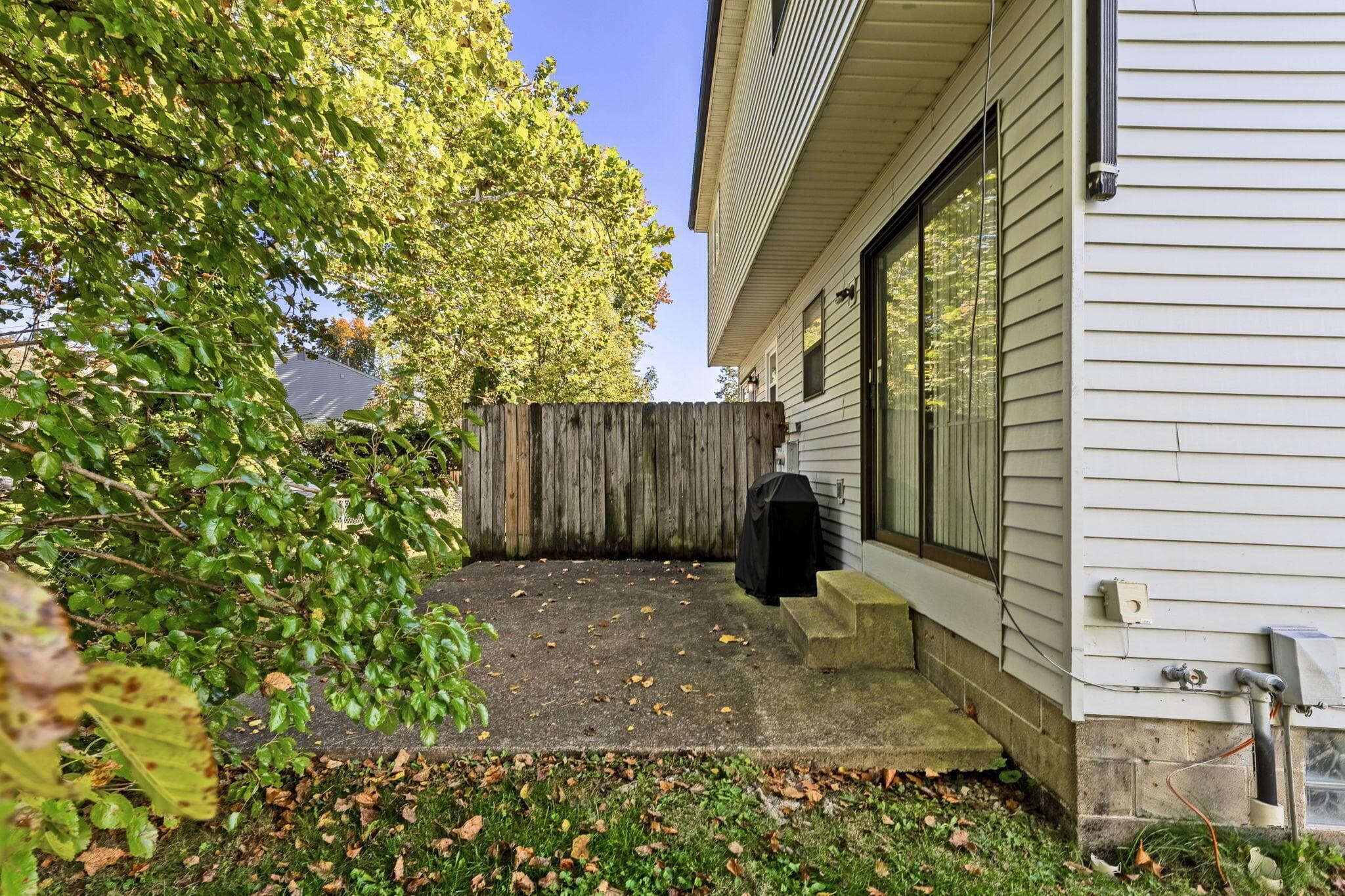 Concrete patio featuring vertical wood fencing and sliding glass door entry