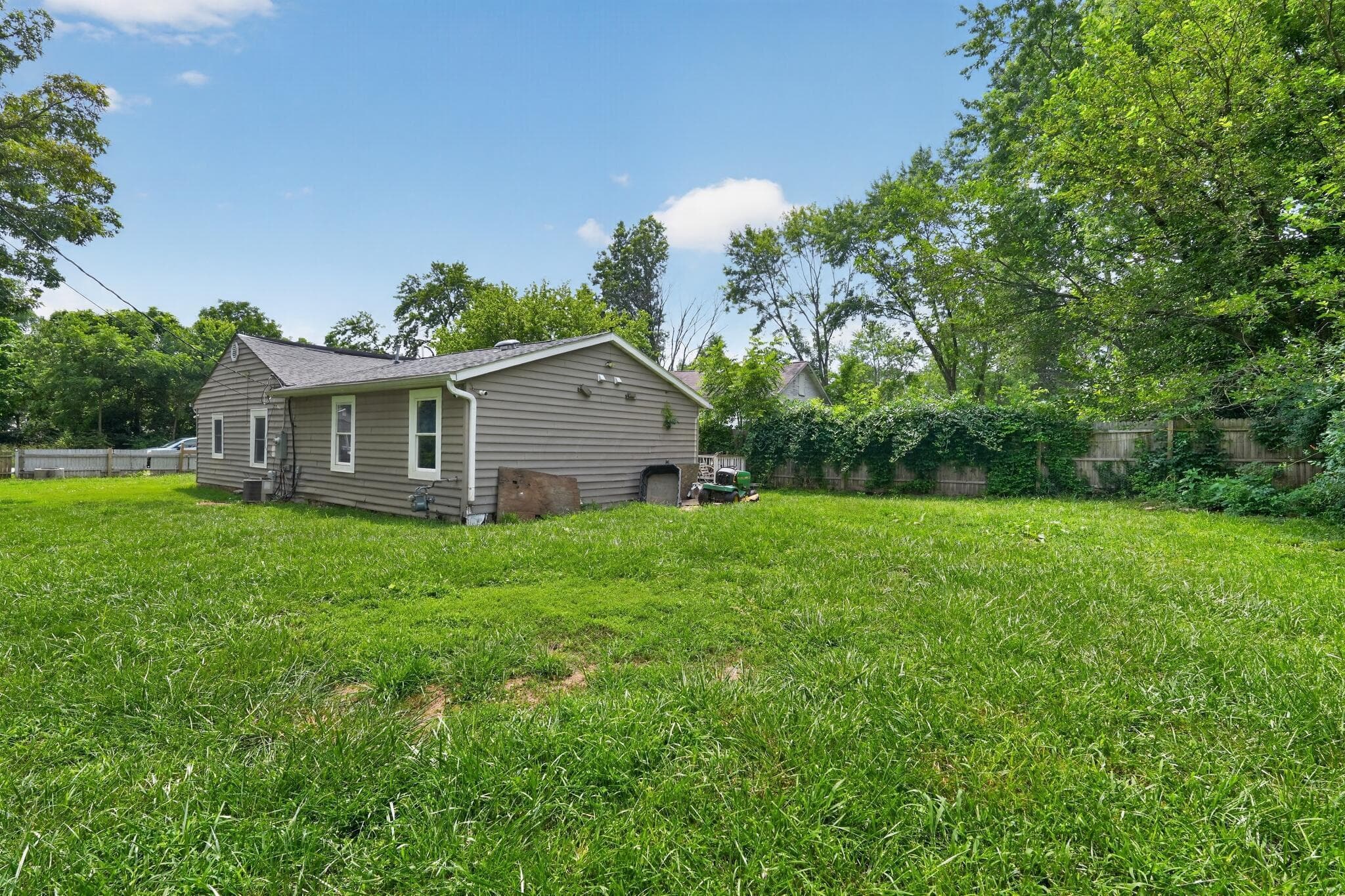 Expansive green lawn with mature trees bordering the property