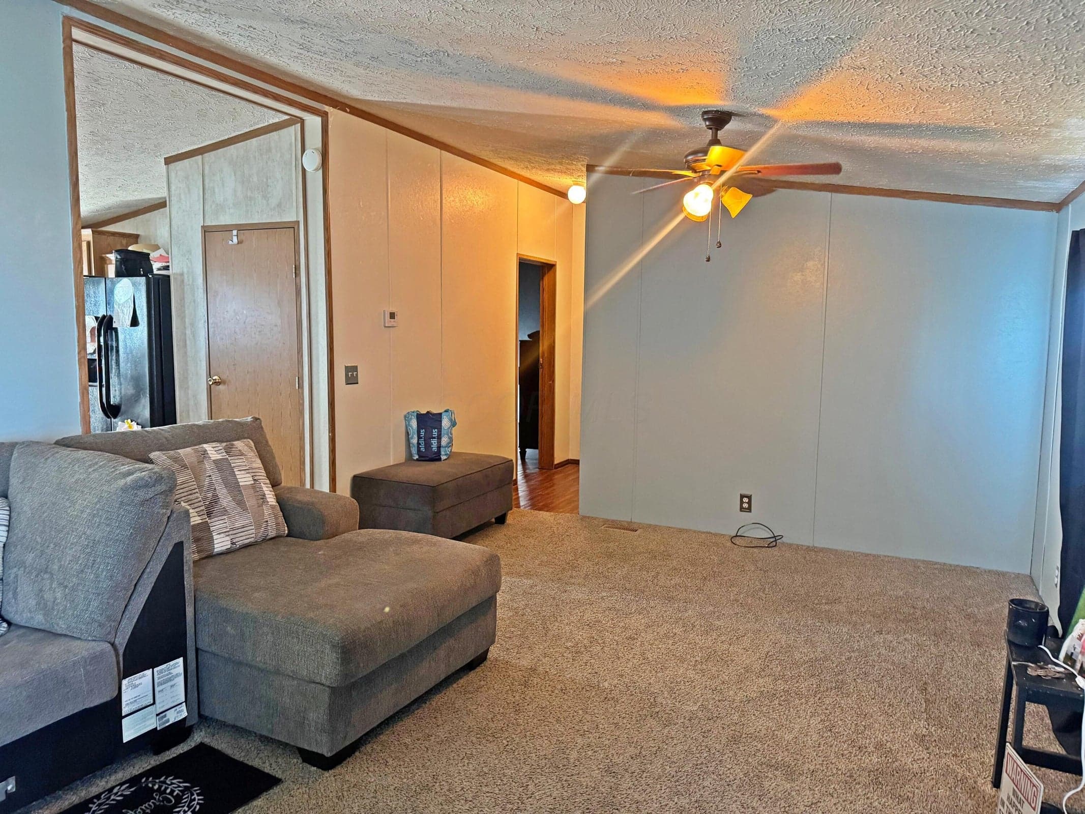 Interior space featuring wall-to-wall carpeting, wood-trim paneling, and a ceiling-mounted light fixture with a central fan