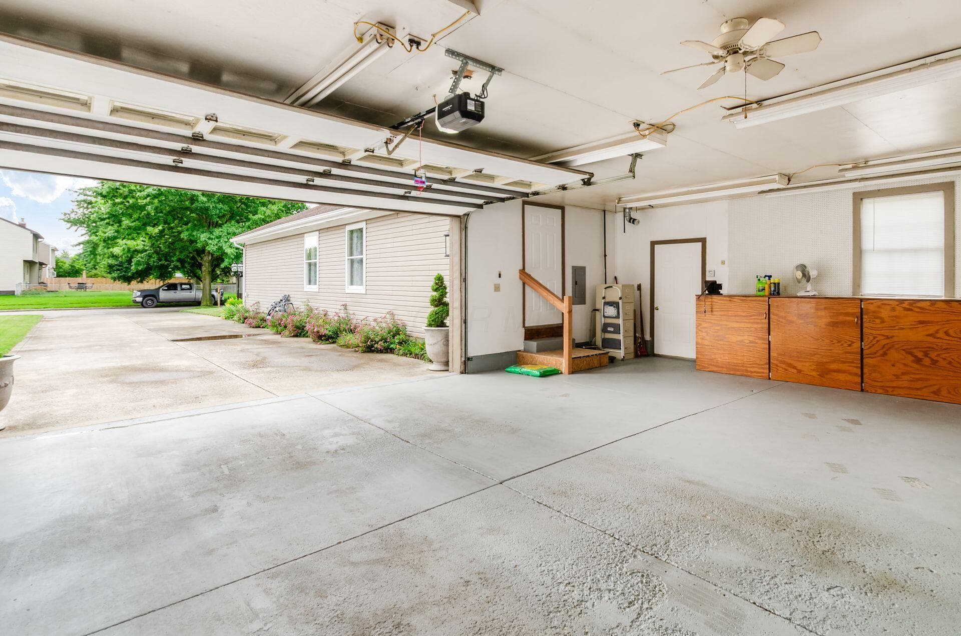 Open garage door looking out front, down the driveway.