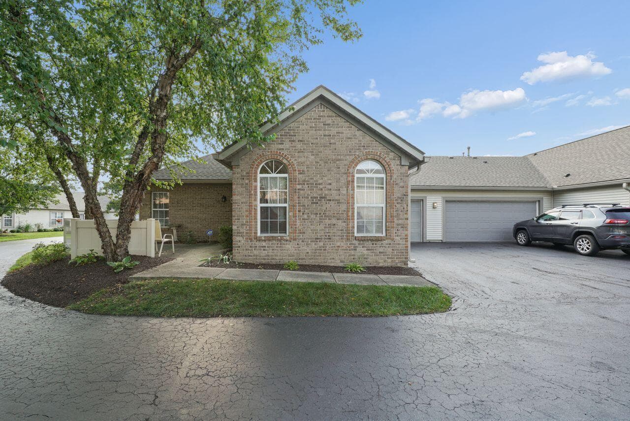 Brick detailing, tall arched windows, and mature trees give this home a distinctive exterior.