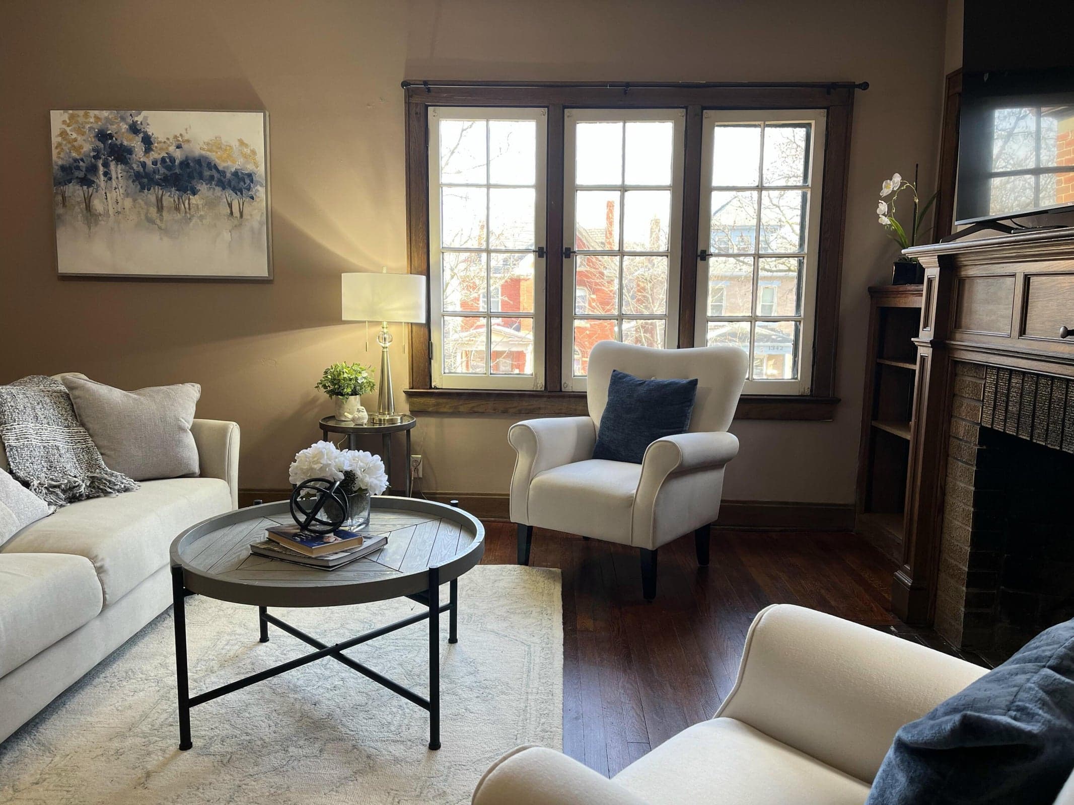 Hardwood flooring, three pane windows, built-in shelving, brown brick fireplace with a wood mantle